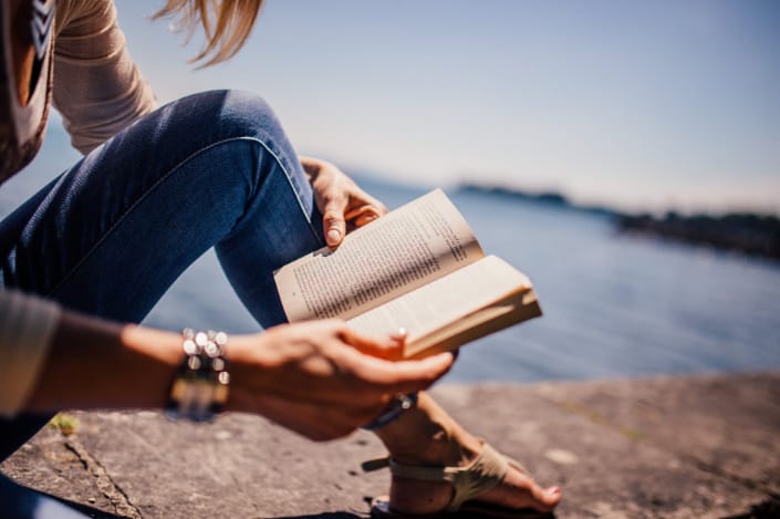 a person reading a book outdoors